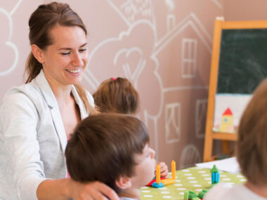 Medium shot happy teacher with kids Medium shot happy teacher with kids